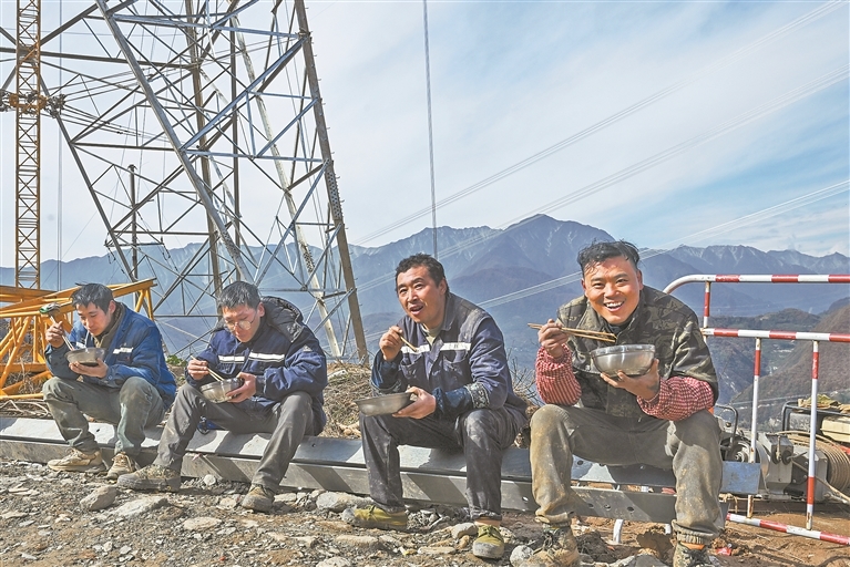 11月20日，工人们席地而坐，开心地吃着午餐。