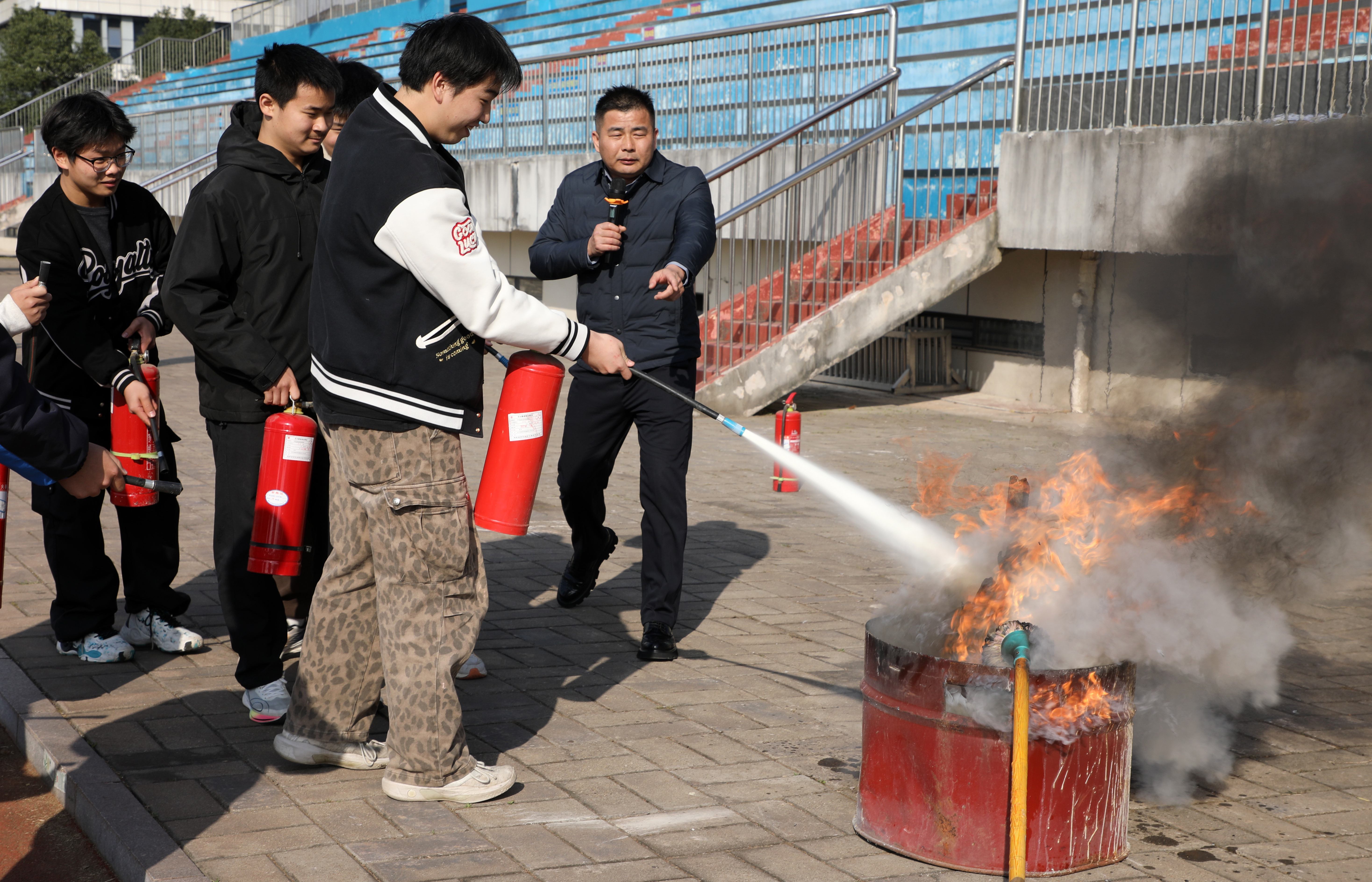 专业消防人员现场指导学生正确使用灭火器