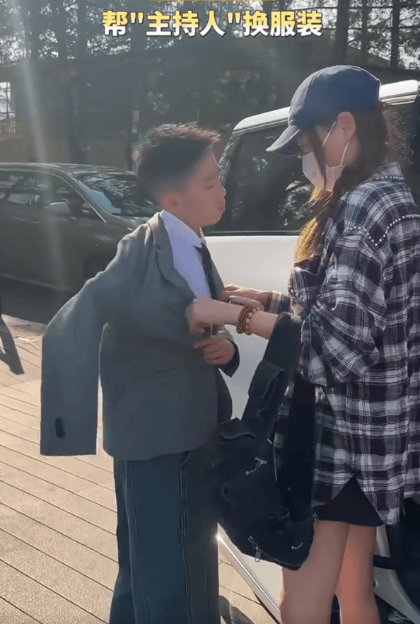 应采儿帮儿子穿衣服。