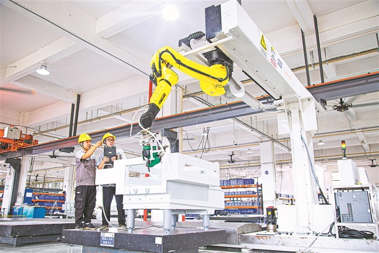 在吉安高新区的江西宇宙电路板设备有限公司生产车间内，工作人员正操控机械臂进行精细的焊接作业。 通讯员 肖 琛摄