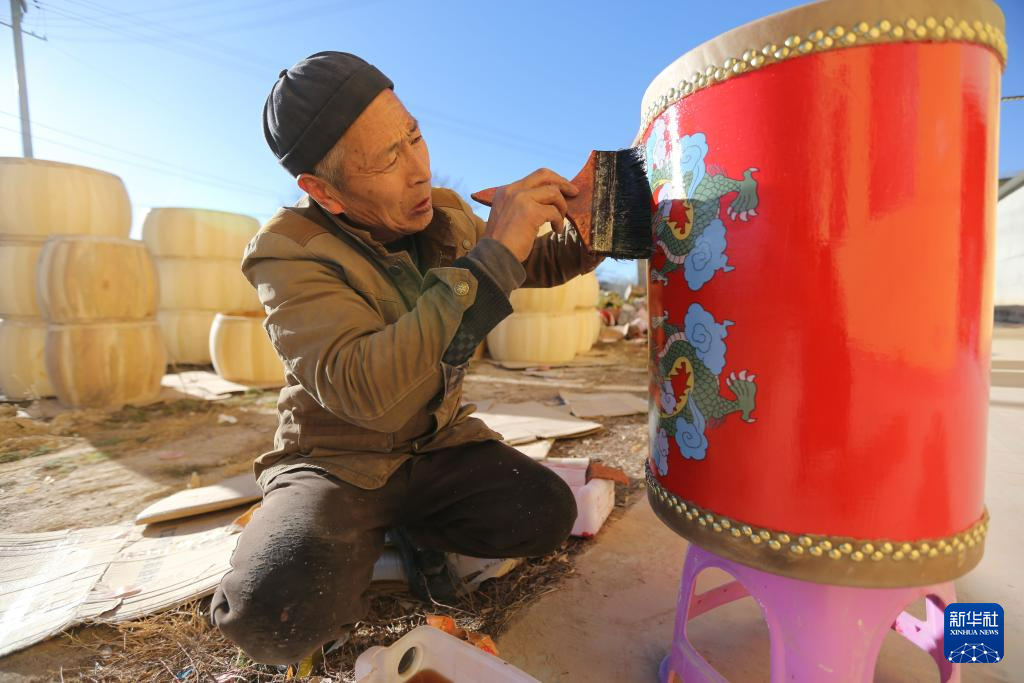 11月27日，手工艺人周天成给牛皮鼓刷清漆。新华社发（王克贤　摄）