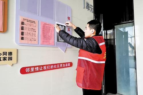 11月26日，在固安县惠文社区金海悦城小区，社区志愿者张贴居民楼专属二维码，引导居民通过线上平台为文明城市创建工作出谋划策。张 琛摄