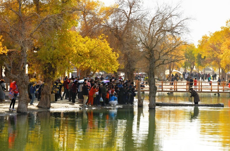 罗布人村寨沙漠文化旅游节期间，游客在观赏罗布人划着卡盆捕鱼。王立华 摄