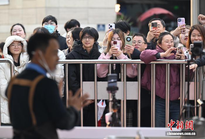 12月12日，不少市民关注“鸡排哥”李俊永。当日，江西景德镇网红“鸡排哥”李俊永全国巡炸之旅来到浙江杭州，当地民众排起百米长队品尝。中新社记者 王刚 摄