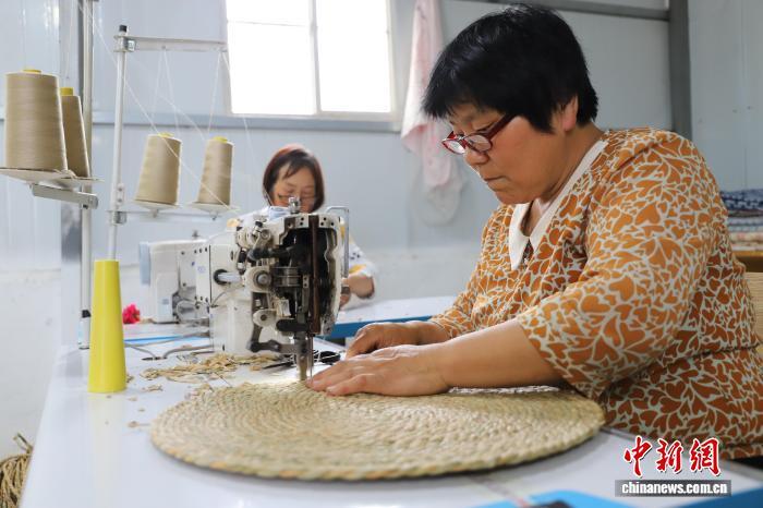 在郓城县潘渡镇杨庙村的盛泽工艺车间里，工人在缝制草编蒲团。郓城县委宣传部供图