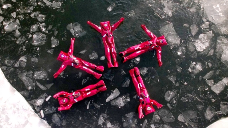 12月5日,在阿勒泰市阿苇滩镇,不少游客身着红色特制防寒服,在阿勒泰冰浮俱乐部体验冰浮项目。张福新摄