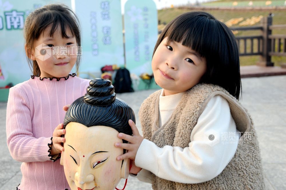 2025年12月7日下午,江西省抚州市南丰县蜜桔湖景区橘子餐厅广场,傩师们在跳傩祈福,吸引省内外游客们驻足观看、拍照,游客们还拿着傩面具拍照留念。