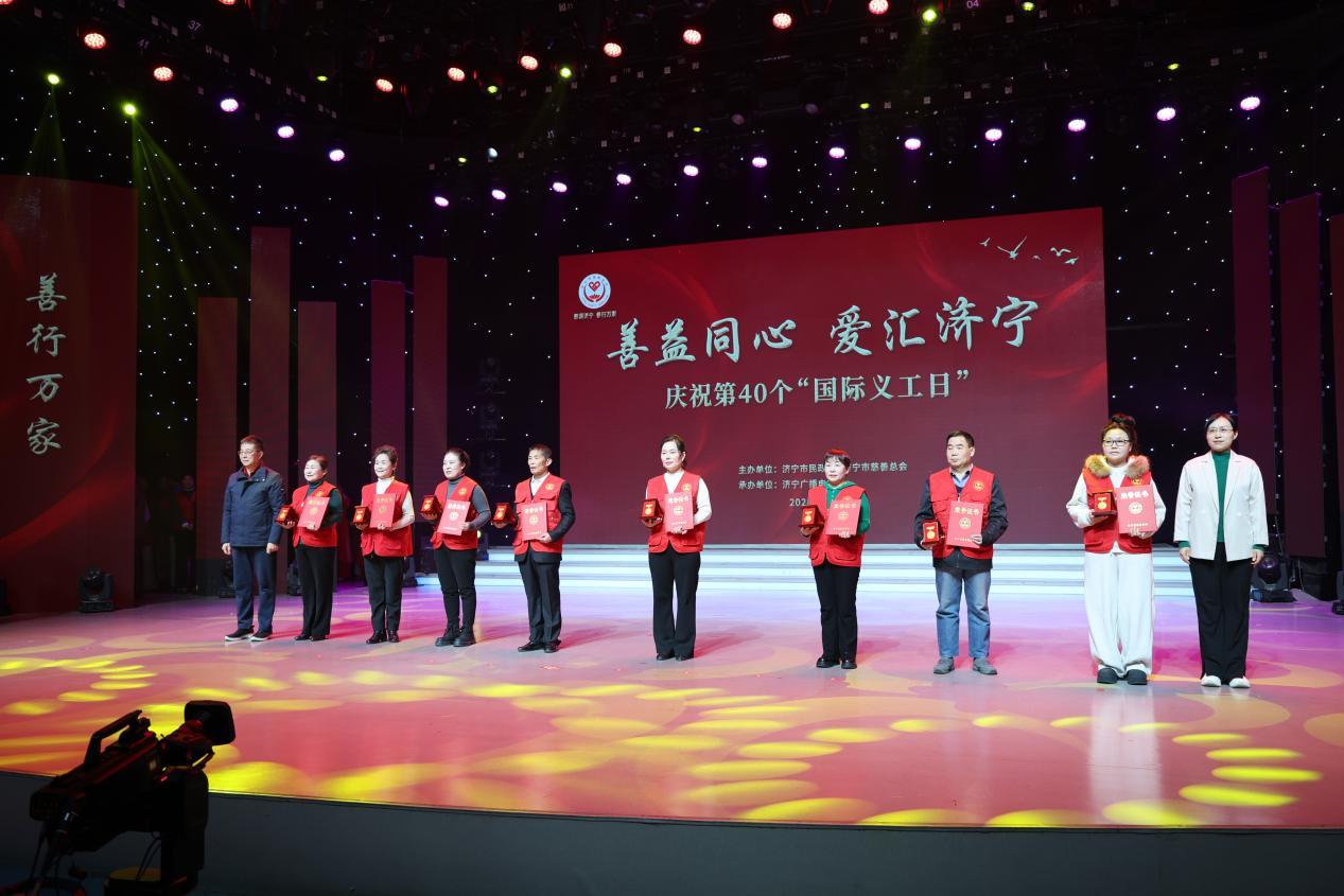 济宁市国资委副主任孙雪（右）、市慈善总会监事会监事长李志文（左）为五星级慈善义工颁发徽章与证书