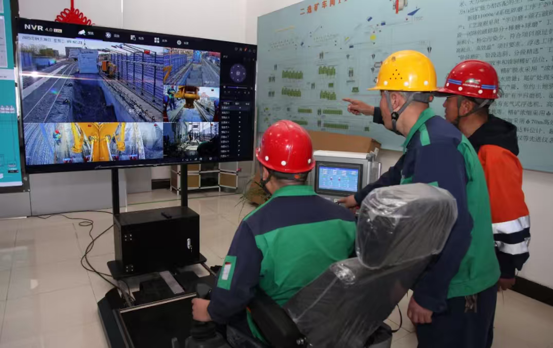 △金川集团镍钴选矿厂，职工正通过电子手柄远程操控智能机械臂清理储料仓，这标志着国内首创的半自磨储料缓冲仓远程清矿系统成功投用。