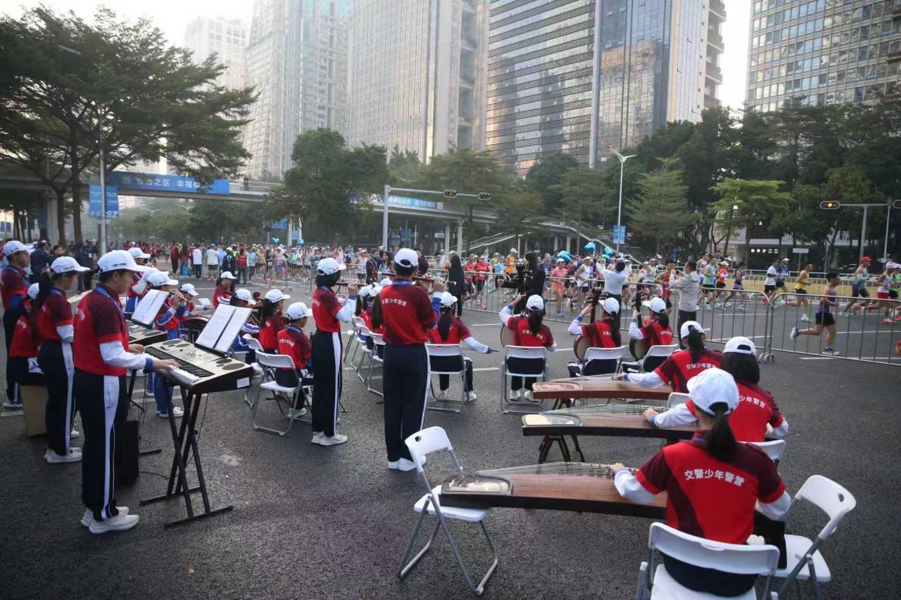 交警少警民乐团用传统音乐合奏为参赛队员加油助威