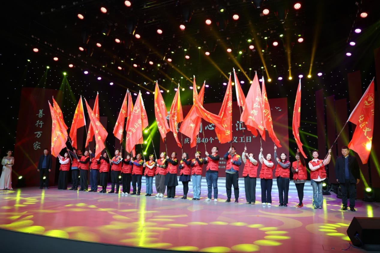 济宁市慈善总会副会长谷卫东（右）、李兵（左）为新命名成立的慈善义工团授旗