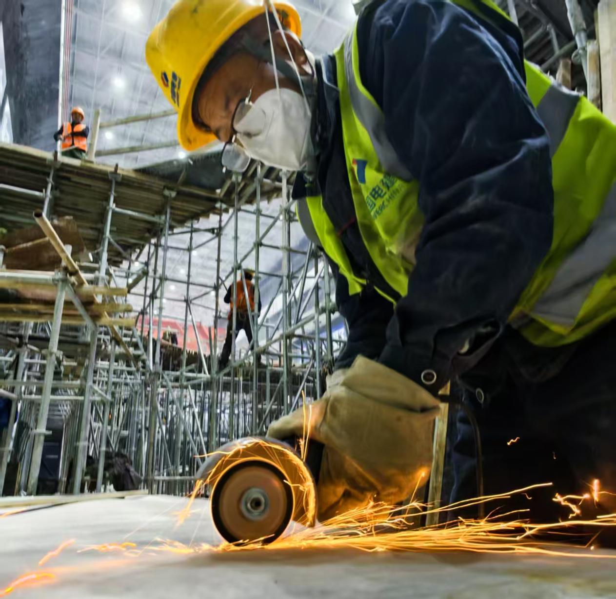 鲁山豫能抽水蓄能电站核心机组总装冲刺阶段，工人在地下厂房进行设备打磨作业。摄影：韩自豪