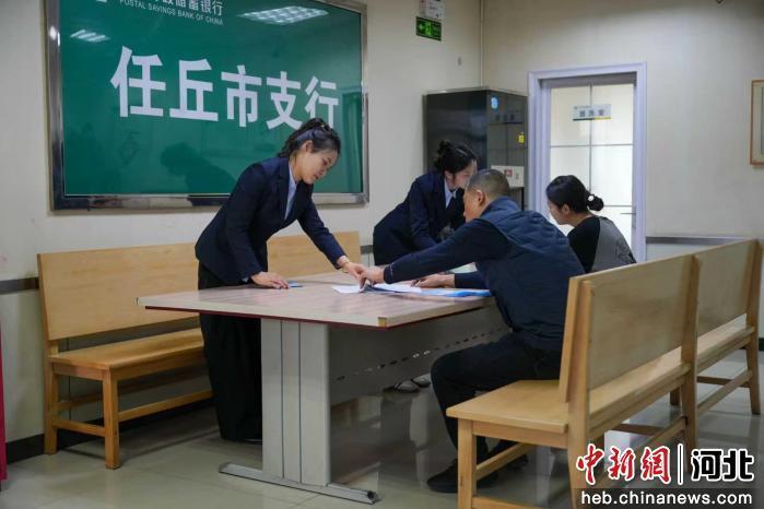图为任丘市一邮储银行,工作人员正在为创业人员办理创业贷款。 刘冲 摄