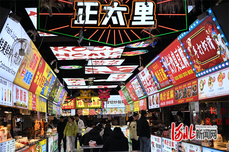 12月8日，游客在石家庄正太里文旅休闲街区品尝各地美食。这条街区由石家庄市新华区原泰华街夜市升级改造而来。