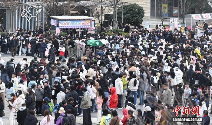 12月12日，江西景德镇网红“鸡排哥”李俊永全国巡炸之旅来到浙江杭州，当地民众排起百米长队品尝。中新社记者 王刚 摄