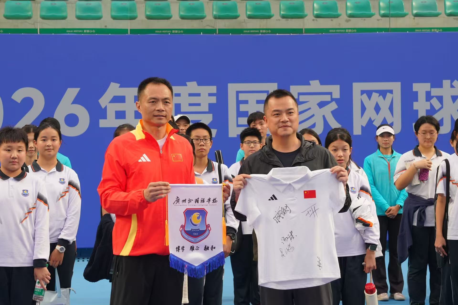 图：国家网球队领队吕亮与广州外国语学校副校长谭齐亮互赠纪念品