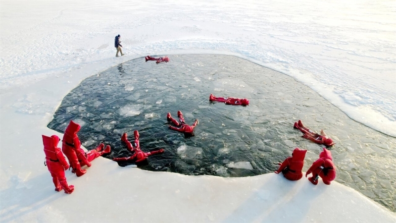 12月5日,在阿勒泰市阿苇滩镇,不少游客身着红色特制防寒服,在阿勒泰冰浮俱乐部体验冰浮项目。张福新摄