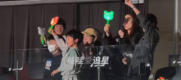 两家人一起挥动应援棒,画面温馨。