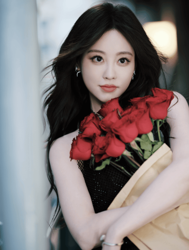 祝绪丹怀抱簇簇红玫瑰,黑色吊带裙衬得肤白明艳。
