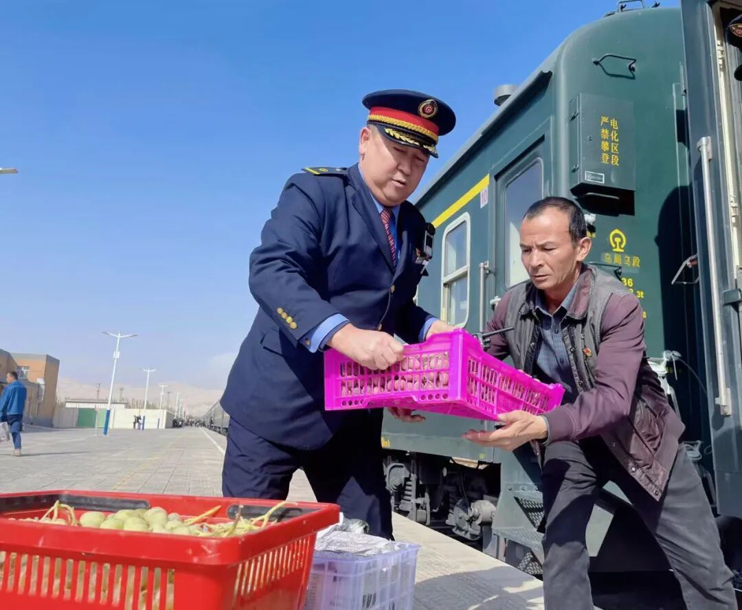 图为列车长坡拉提汗正在帮助沿线农户搬运货物到“列车巴扎”上售卖。(通讯员:裴航/摄)
