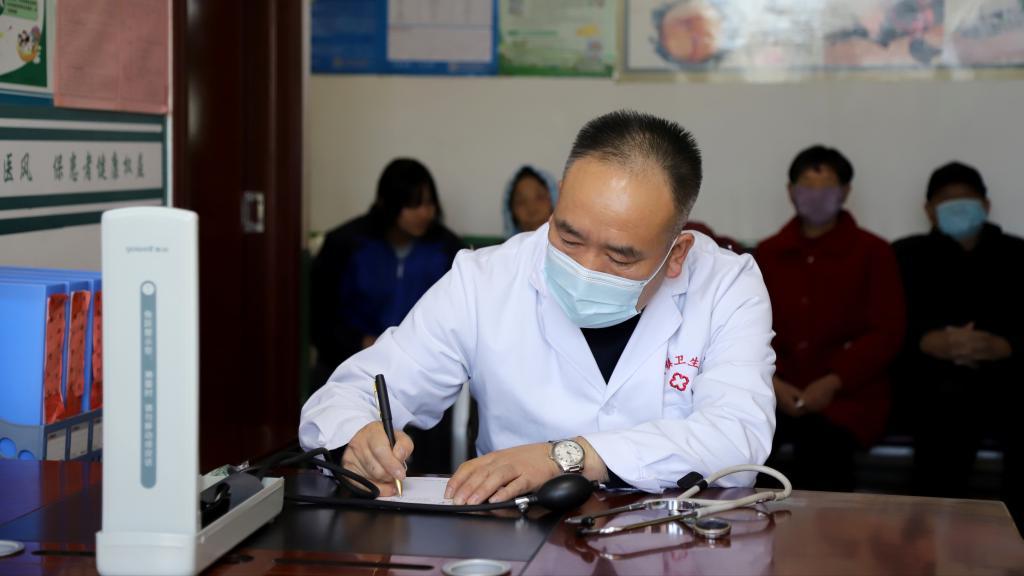 张万泰在案头前为患者写医嘱　新华社发