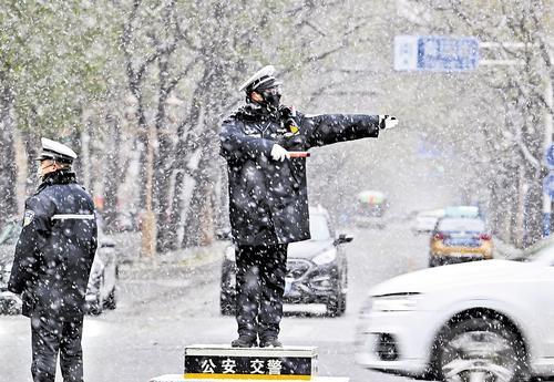 12月12日，在石家庄市裕华东路和青园街交叉口，交警冒雪疏导交通。本报记者 贾 恒摄