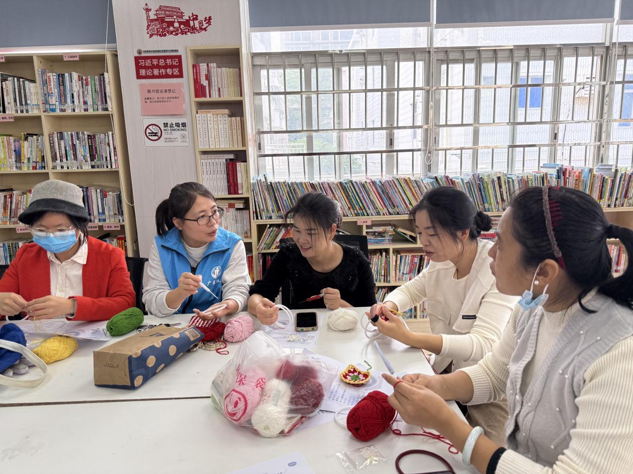 工作人员指导宝妈学习钩织技巧