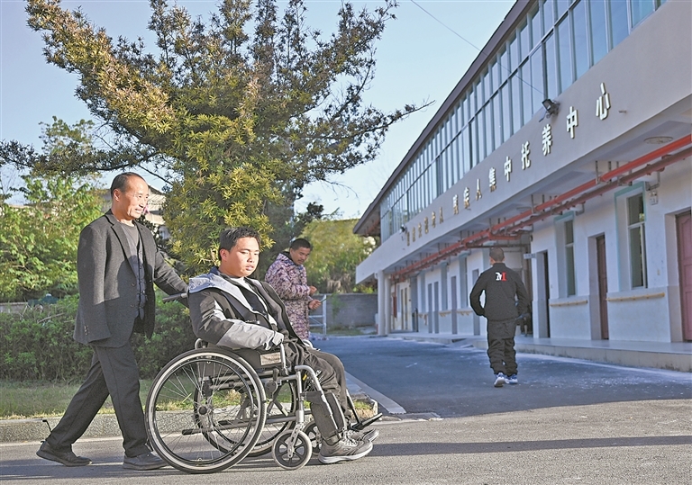 在万载县重度失能残疾人托养中心，周毛根照料托养的残疾人。