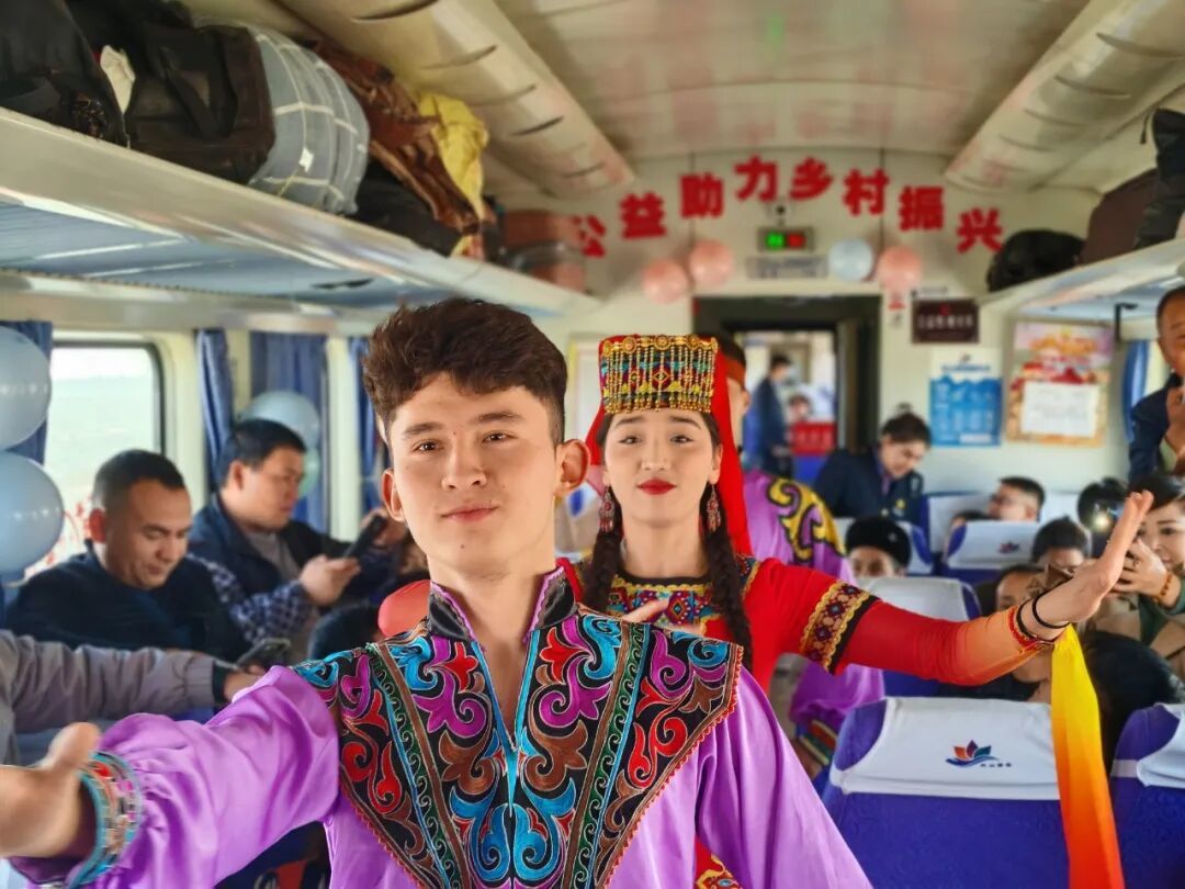 图为列车上开展“公益助力 乡村振兴”主题活动,列车乘务员与旅客一起载歌载舞。(通讯员:玛依然·赛买提/摄)