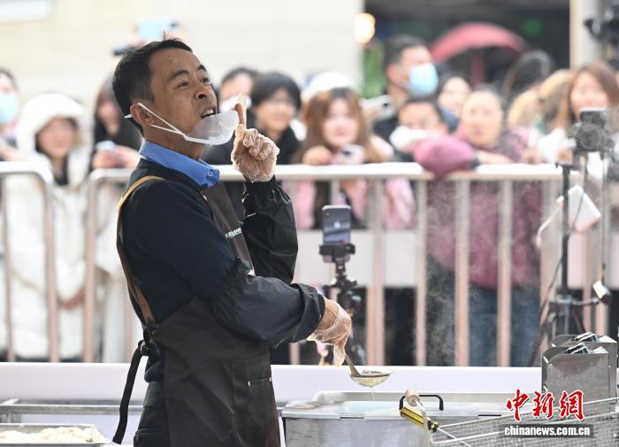 12月12日，“鸡排哥”李俊永和市民互动。当日，江西景德镇网红“鸡排哥”李俊永全国巡炸之旅来到浙江杭州，当地民众排起百米长队品尝。中新社记者 王刚 摄