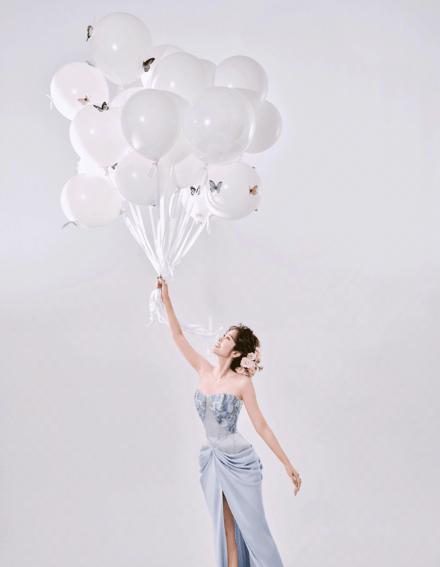唐艺昕手持白色气球,背景的简约色调衬出礼裙的清新。
