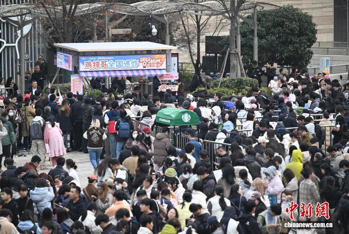 12月12日，江西景德镇网红“鸡排哥”李俊永全国巡炸之旅来到浙江杭州，当地民众排起百米长队品尝。中新社记者 王刚 摄