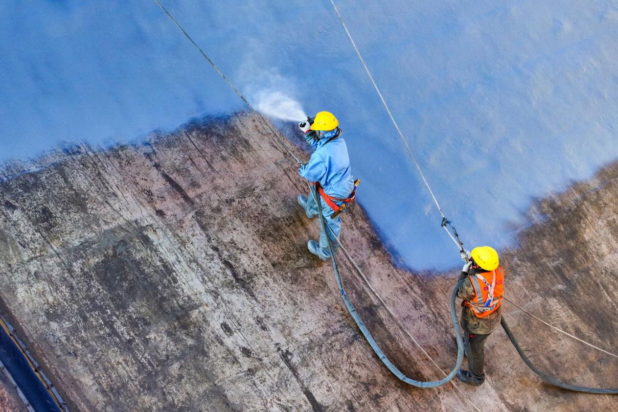 鲁山豫能抽水蓄能电站于2022年1月正式开工，目前上水库大坝主体施工基本完成，图为建设者正在为大坝做防水层喷涂工艺。摄影：何进文