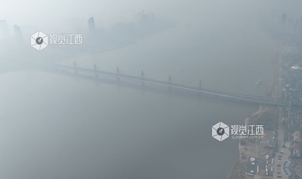 12月19日上午，航拍镜头中的南昌赣江两岸，高层建筑在雾霾中若隐若现。