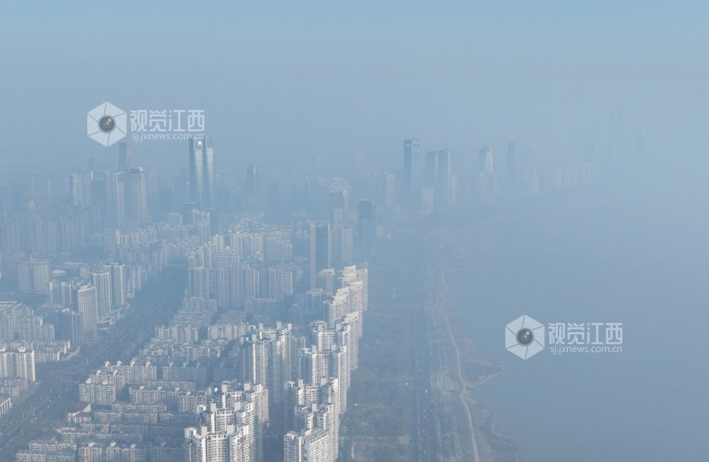 12月19日上午，航拍镜头中的南昌赣江两岸，高层建筑在雾霾中若隐若现。