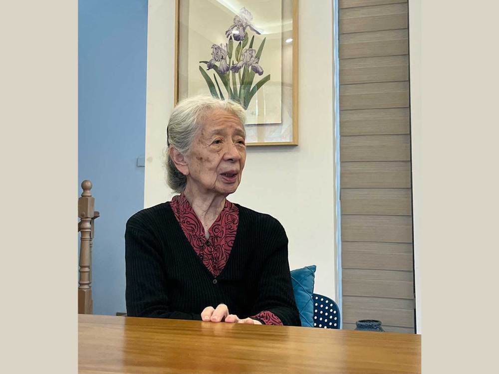 常沙娜坐在她的花卉写生作品前（资料照片）　新华社记者　张玉洁　摄