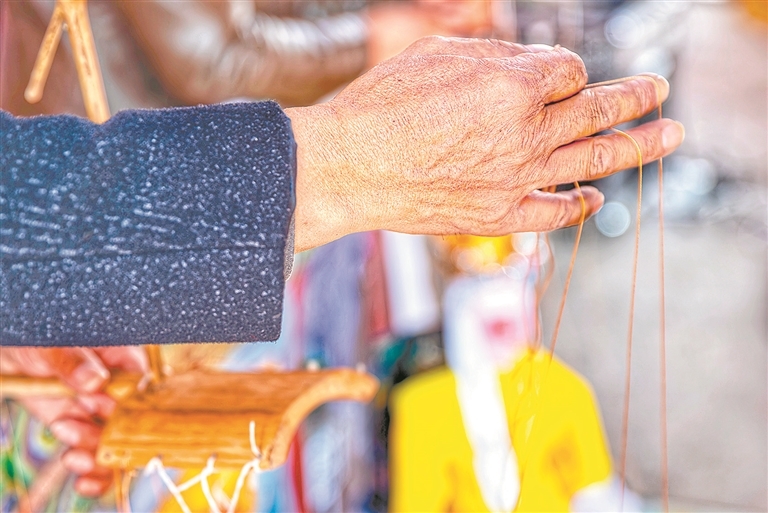 谢帮银指尖翻飞，十几根细丝线在他手中收放自如。