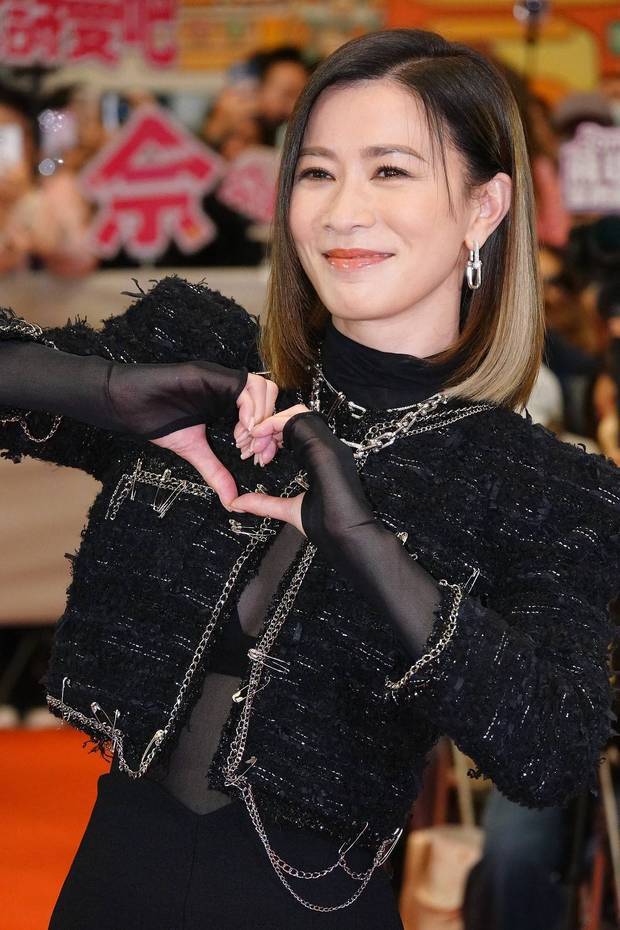 佘诗曼侧对镜头,双手比心。