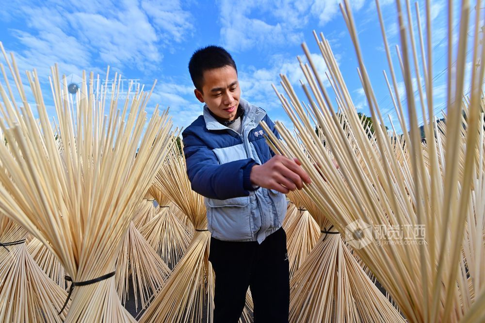 2025年12月16日，江西省宜春市万载县仙源乡统战信息员在仙源村帮助企业晾晒加工好的竹丝。