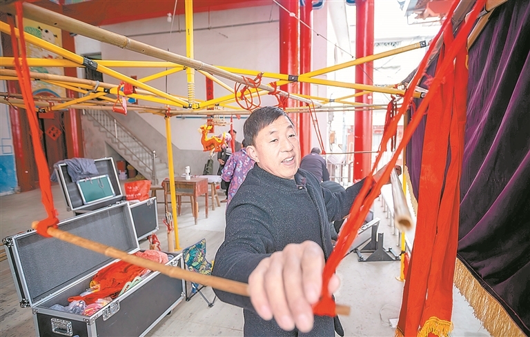 谢帮银正在搭建戏台。