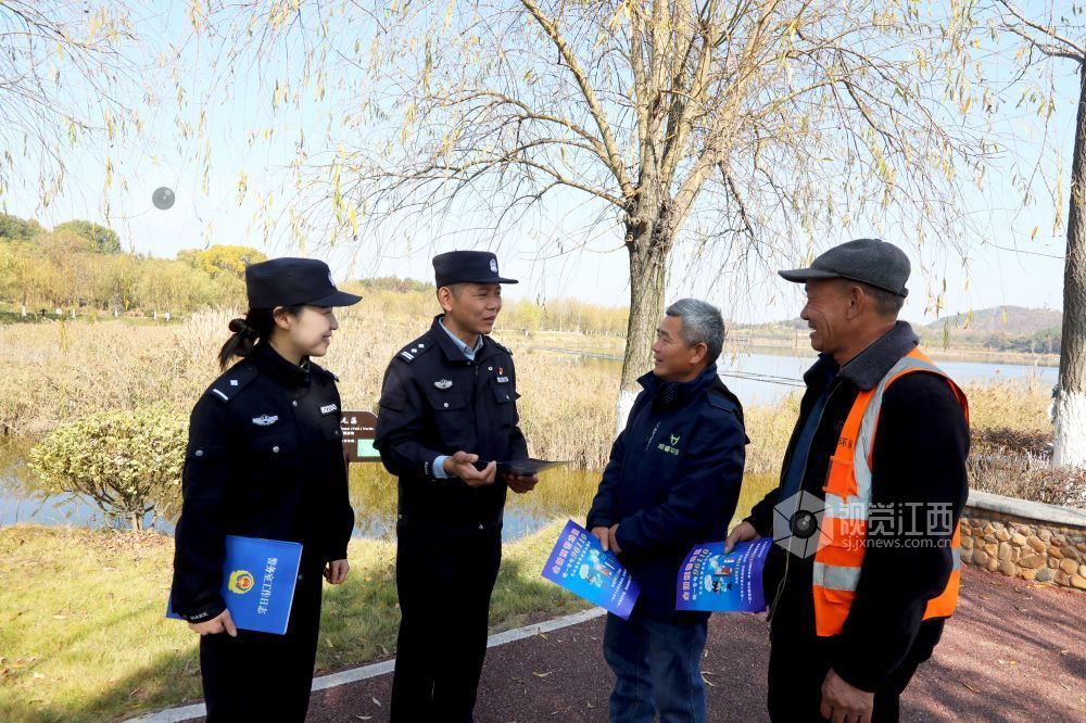 2025年12月15日，在江西省分宜县介溪湿地公园，分宜县公安局民警向群众宣传保护候鸟知识。