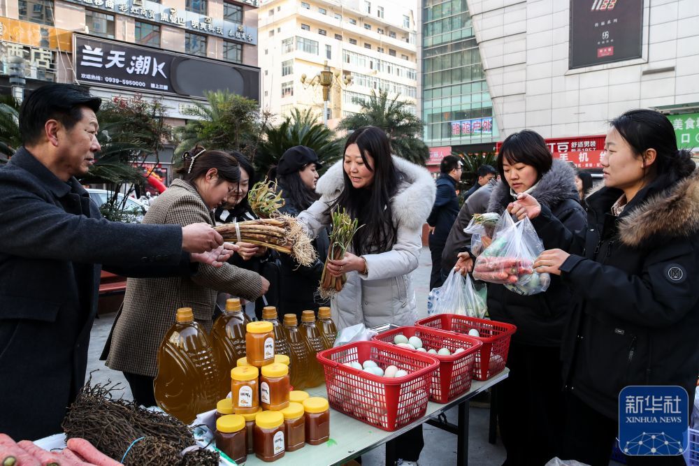 ↑12月13日，居民在陇南市武都区“冬至大集”上选购特色农产品。