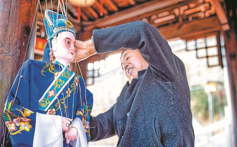 谢帮银认真打理自己的木偶。对他而言，每个木偶都是宝贝，有些木偶已陪伴他30余年。