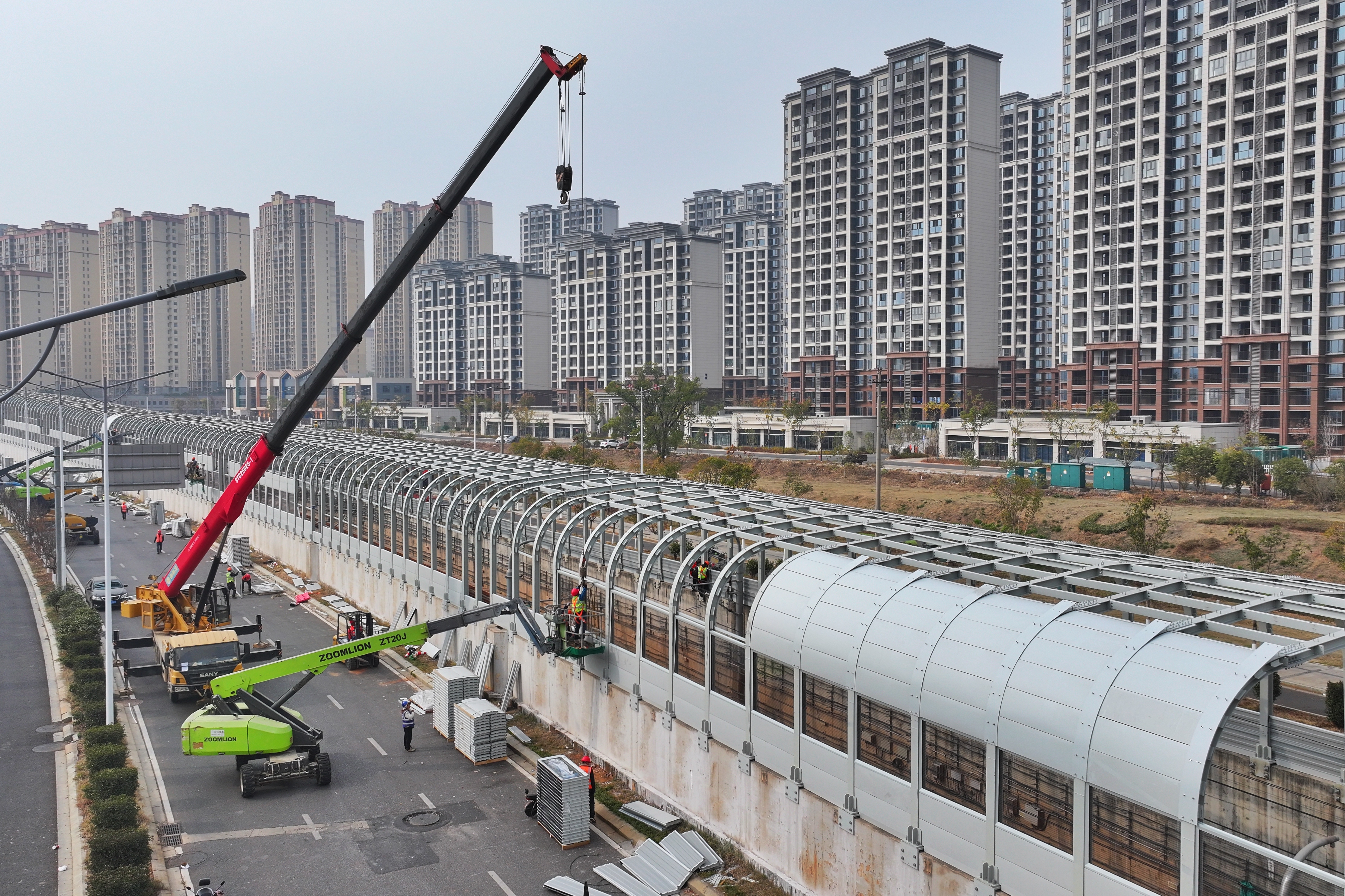 ▲图为12月12日，工人抓紧全封闭式声屏障加装施工。王蕴蓉摄