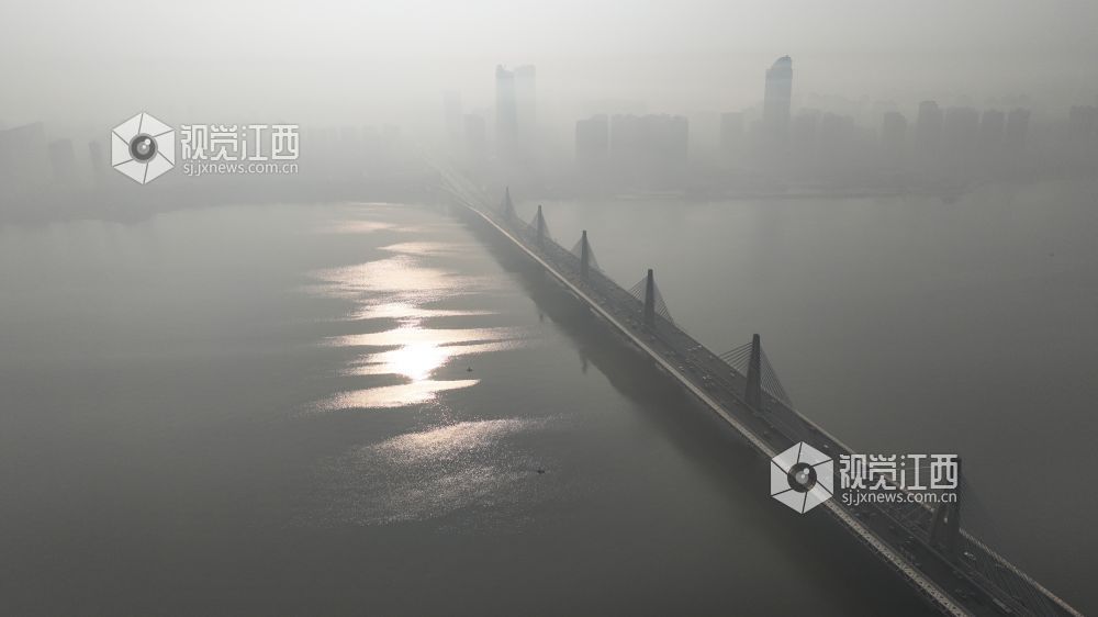 12月19日上午，航拍镜头中的南昌赣江两岸，高层建筑在雾霾中若隐若现。