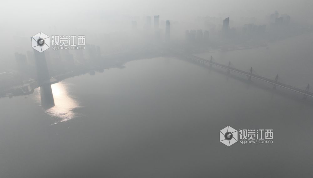 12月19日上午，航拍镜头中的南昌赣江两岸，高层建筑在雾霾中若隐若现。