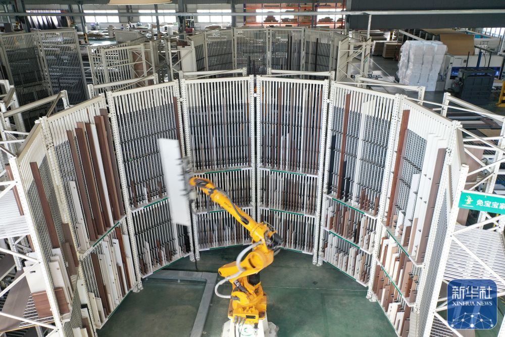 ↑ 12月15日，在位于浙江省湖州市德清县乾元镇的德华兔宝宝装饰新材股份有限公司家居产业园，智能分拣机械臂在分拣家具板材（无人机照片）。新华社发（倪立芳摄）