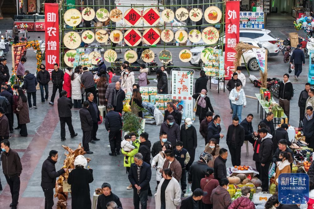 ↑12月13日，居民在陇南市武都区“冬至大集”上选购特色农产品（无人机照片）。