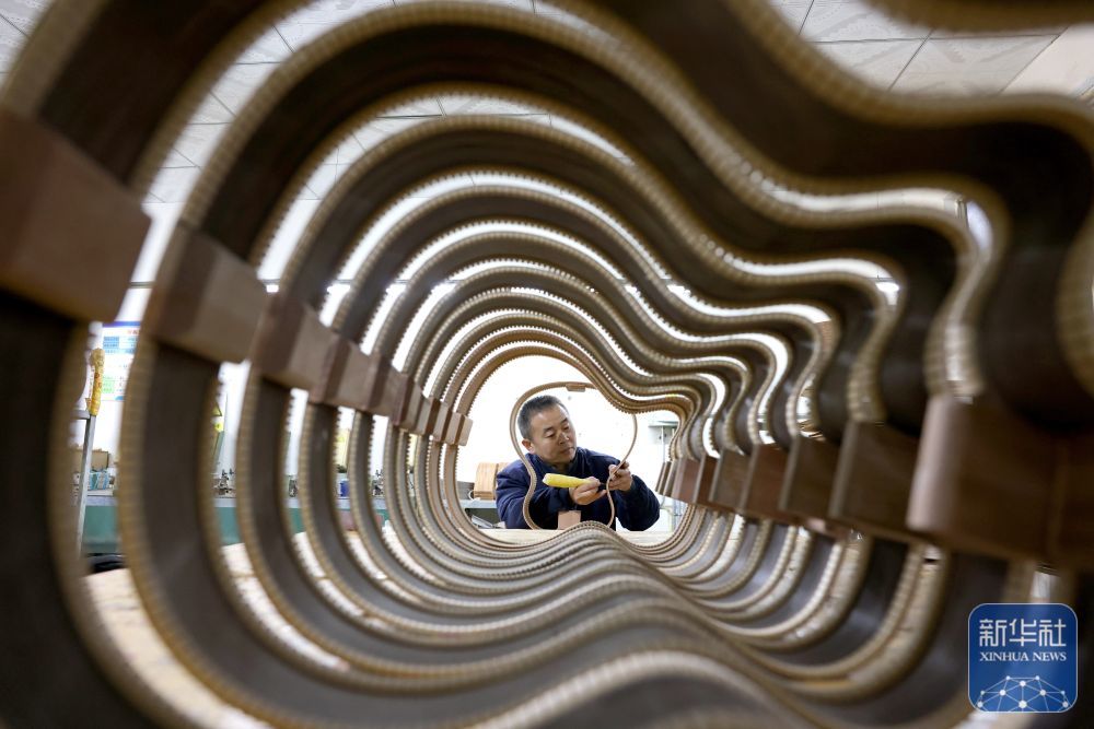 ↑ 12月15日，在山东省枣庄市市中区孟庄镇一家吉他生产企业，技术工人在生产吉他。新华社发（孙中喆摄）