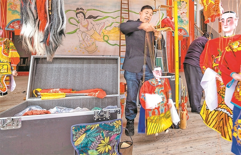 谢帮银整理演出需要的木偶。